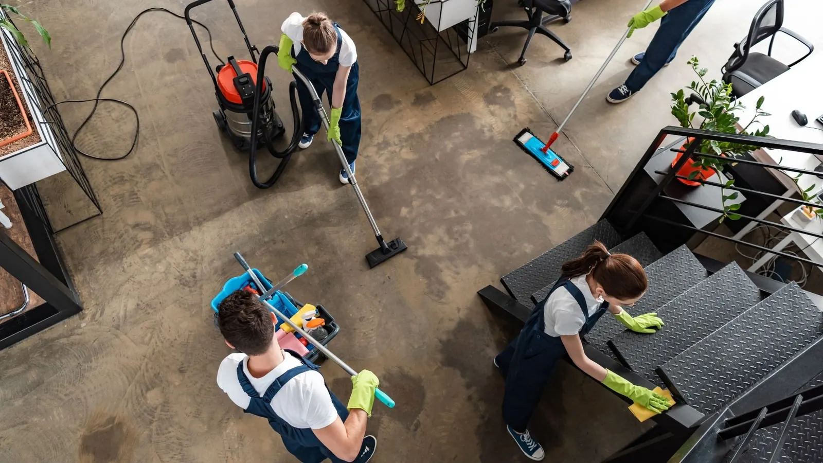 Cleaning crew vacuuming and mopping a commercial workspace floor